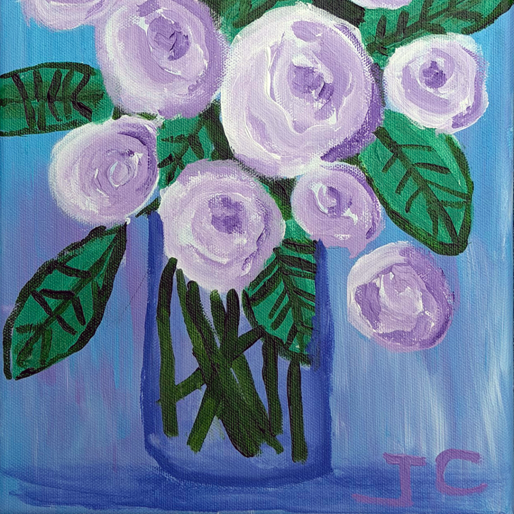 Large purple flowers with green leaves in clear vase on blue background