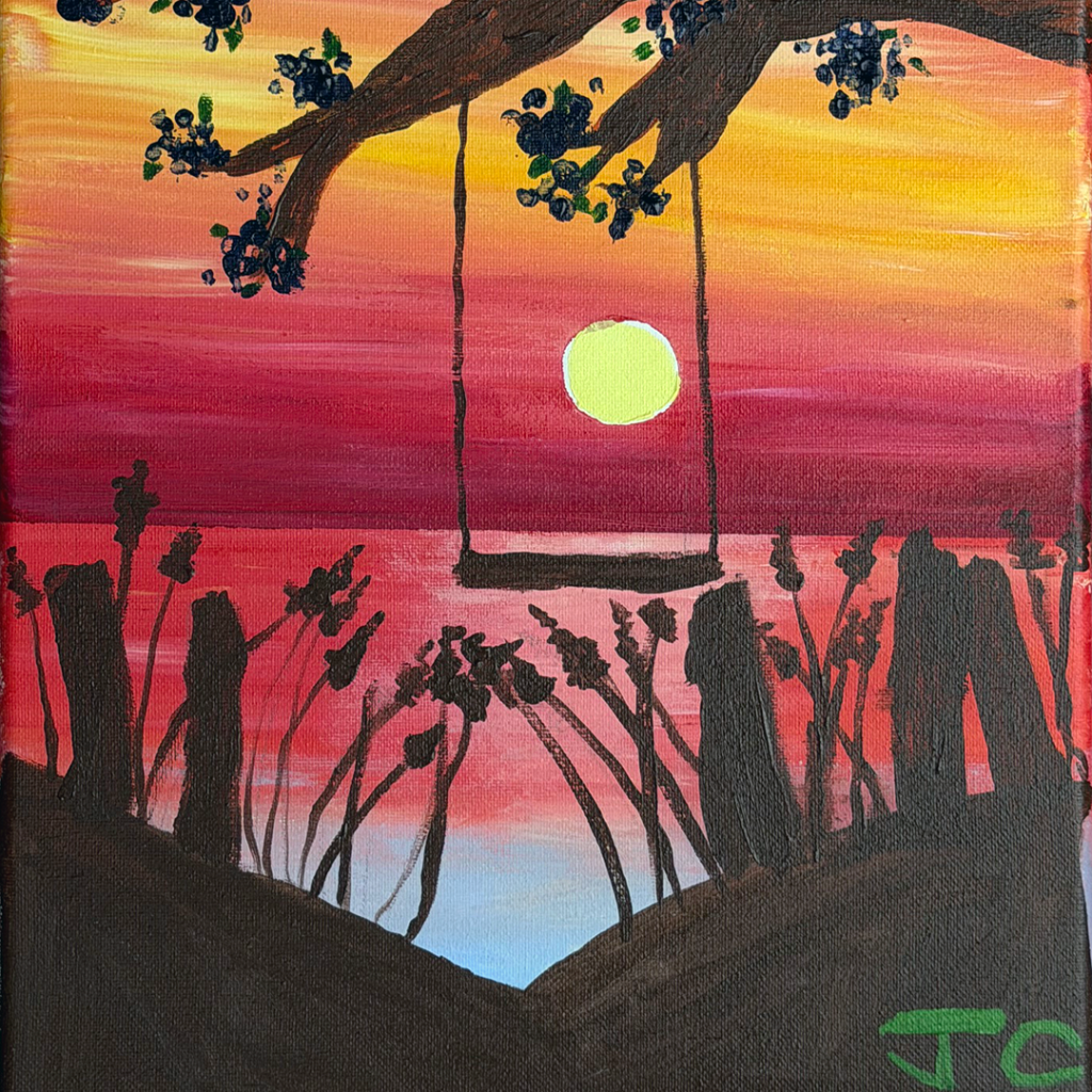Deep sunset with reeds in foreground and a swing in center